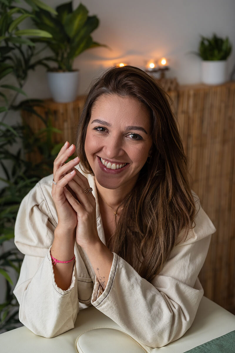 Portrait professionnel et souriant de Naty, esthéticienne spécialisée dans le massage facial.