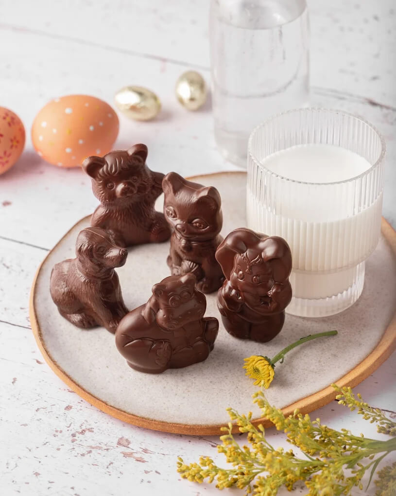 Chocolats de Pâques en forme d'animaux sur une table décorée dans un style champêtre et élégant.