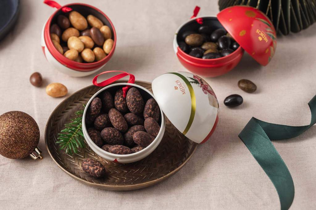 Dragées dans des boîtes sphériques, décorées pour Noël, semblables à des ornements de sapin.