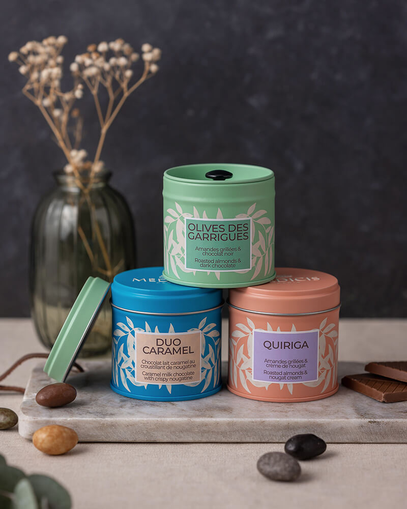 Boîtes élégantes de dragées élégamment disposées sur un plateau en marbre.