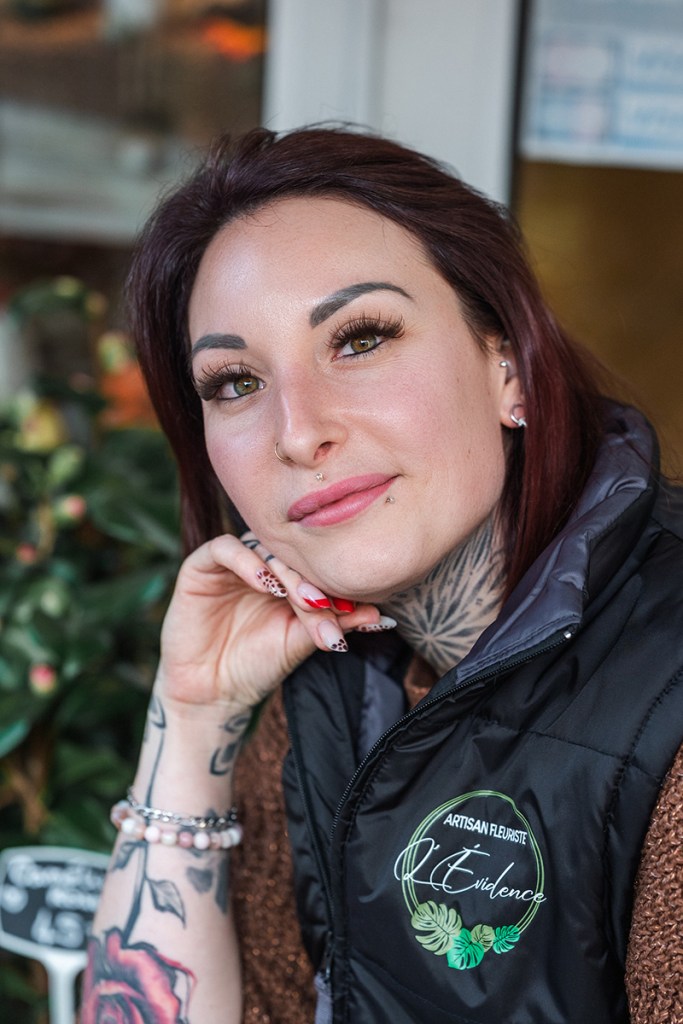 Gros plan sur le visage souriant d'une jeune fleuriste.